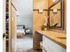 Bathroom featuring granite countertop vanity, neutral tile, and stylish decor with a peek into the adjacent bedroom at 955 Eudora St # 307E, Denver, CO 80220