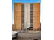 Brick building with balconies, concrete center, dark awning, and sidewalk access to main entrance at 955 Eudora St # 307E, Denver, CO 80220