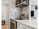 Updated kitchen showcasing stainless steel appliances, modern cabinetry, and a sleek backsplash at 955 Eudora St # 307E, Denver, CO 80220