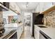 Modern kitchen showcasing white cabinetry, stainless steel appliances, and a sleek backsplash at 955 Eudora St # 307E, Denver, CO 80220