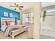 Bright bedroom features a wooden bed frame, blue accent wall, and bathroom with a tub and shower at 8065 E 21St Ave, Denver, CO 80238