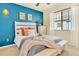 Bright bedroom features blue accent wall, neutral furniture, and comfortable furnishings for a cozy and inviting space at 8065 E 21St Ave, Denver, CO 80238