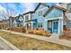 Charming blue townhomes with well-maintained lawns and sidewalks offer inviting curb appeal at 8065 E 21St Ave, Denver, CO 80238