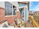 Inviting covered front porch with brick accents, seating area, and charming decorative touches at 8065 E 21St Ave, Denver, CO 80238