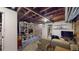 Basement living area with exposed ceiling and brick, and bright overhead lighting at 126 S Clarkson St, Denver, CO 80209
