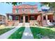 Charming brick duplex featuring a covered front porch and well-maintained lawn at 126 S Clarkson St, Denver, CO 80209