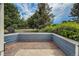View of gravel patio bordered by wood-clad walls and mature landscaping at 1419 Red Mountain Dr # 126, Longmont, CO 80504