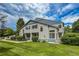 Charming townhome with blue accents, lush lawn, and mature trees under a bright blue sky at 1419 Red Mountain Dr # 126, Longmont, CO 80504