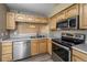 A closer look at the kitchen, featuring stainless appliances, wood cabinets, and an open view into another room at 1419 Red Mountain Dr # 126, Longmont, CO 80504