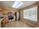 Bright kitchen featuring stainless steel appliances, wood cabinets, wood-look flooring, and a window overlooking the yard at 1419 Red Mountain Dr # 126, Longmont, CO 80504