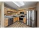 A well-lit kitchen showcases stainless steel appliances, wood cabinets, and durable wood-look flooring at 1419 Red Mountain Dr # 126, Longmont, CO 80504