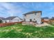 Backyard view of a two-story home with a well-maintained lawn and wooden deck, perfect for outdoor gatherings at 600 Balsa Dr, Castle Rock, CO 80104