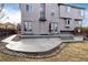 Inviting backyard with stone patio, landscaped edges, and a view of the home's exterior at 7636 S Allison Ct, Littleton, CO 80128