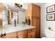Well-lit bathroom featuring vanity, cabinets for storage, and a toilet at 7636 S Allison Ct, Littleton, CO 80128