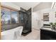 Bathroom featuring a freestanding tub and a tiled glass shower with a black door at 7636 S Allison Ct, Littleton, CO 80128