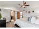 Bedroom with a ceiling fan, flower artwork, and doorways to an ensuite bathroom and staircase at 7636 S Allison Ct, Littleton, CO 80128