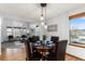 Charming dining room featuring hardwood floors, modern lighting, and a view into the living room at 7636 S Allison Ct, Littleton, CO 80128