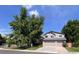 Charming home with a three-car garage and lush trees providing ample shade on a sunny day at 7636 S Allison Ct, Littleton, CO 80128