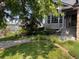 Well manicured front yard with mature trees and front porch at 7636 S Allison Ct, Littleton, CO 80128