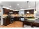 Well-appointed kitchen features granite countertops, wood cabinetry and eat-in breakfast bar at 7636 S Allison Ct, Littleton, CO 80128