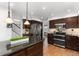 Spacious kitchen features stainless appliances, dark wood cabinetry and granite countertops at 7636 S Allison Ct, Littleton, CO 80128