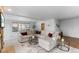 Open concept living area features neutral decor, large windows and flows into a kitchen at 7636 S Allison Ct, Littleton, CO 80128