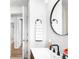 Elegant bathroom features a modern vanity with a black faucet, round mirror, and stylish fixtures at 4300 Osage St, Denver, CO 80211