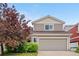 The exterior of a home featuring a two-car garage, neutral siding, and a well-kept front yard with a tree at 5536 Kirk St, Denver, CO 80249