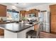 Well-lit kitchen featuring stainless steel refrigerator, wood cabinets, and a stylish island with seating at 5536 Kirk St, Denver, CO 80249