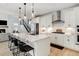 Modern kitchen boasting white cabinets, stainless steel appliances, a central island with seating, and modern pendant lighting at 6264 E 143Rd Dr, Thornton, CO 80602