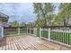 Wooden deck and green backyard with mature trees and a privacy fence, creating a serene outdoor space at 10723 Cherry Ct, Thornton, CO 80233