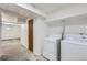 Basement laundry area with washer and dryer hookups, stone-look flooring, and access to additional storage or living space at 10723 Cherry Ct, Thornton, CO 80233
