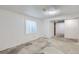Basement room featuring a window for natural light and unique stone-look flooring, freshly painted in a crisp white at 10723 Cherry Ct, Thornton, CO 80233