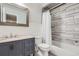 Bathroom featuring gray vanity, white countertops, a tub with white tile and a shower curtain at 10723 Cherry Ct, Thornton, CO 80233