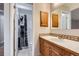 Well-lit bathroom featuring wood cabinets, a large mirror, and a shower with black and white curtain at 10723 Cherry Ct, Thornton, CO 80233