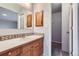 Bathroom featuring wood cabinets, white countertops, decorative tile, and a large mirror at 10723 Cherry Ct, Thornton, CO 80233