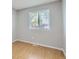 Neutral bedroom with a large window providing natural light and hardwood floors at 10723 Cherry Ct, Thornton, CO 80233