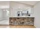 Open kitchen with white cabinets, stainless steel appliances, and a stone-clad breakfast bar at 10723 Cherry Ct, Thornton, CO 80233