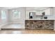 Bright kitchen with stone-clad breakfast bar, white cabinets, stainless steel appliances, and adjacent dining area at 10723 Cherry Ct, Thornton, CO 80233