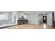 Open-concept living space with wood floors, a modern kitchen and decorative brick accent at 10723 Cherry Ct, Thornton, CO 80233