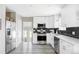 Modern kitchen with white cabinets, stainless steel appliances, and dark tile backsplash at 1531 W Dakota Ave, Denver, CO 80223