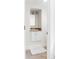 A clean, well-lit bathroom vanity with marble countertop, white cabinets, and a decorative mirror at 623 S Logan St, Denver, CO 80209