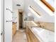 An elegant bathroom with a soaking tub, skylights, and a glass-enclosed shower at 623 S Logan St, Denver, CO 80209