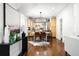 Dining room with modern light fixture, wood floors, and adjoining kitchen at 623 S Logan St, Denver, CO 80209