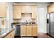 Well-lit kitchen with modern appliances, wooden cabinets, and a striking backsplash at 623 S Logan St, Denver, CO 80209