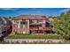 Back exterior with multiple decks, brick, and an expansive well-maintained yard at 5672 S Nome St, Englewood, CO 80111