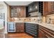 Custom bar area with wooden cabinets, wine storage, granite countertops, and a beverage fridge at 5672 S Nome St, Englewood, CO 80111