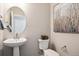 Cozy half bath with pedestal sink, round mirror, and decorative touches for a charming and functional space at 451 Interlocken Blvd # 101, Broomfield, CO 80021