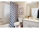 Bright bathroom featuring a tub, shower with patterned curtain, toilet, vanity, and framed artwork at 451 Interlocken Blvd # 101, Broomfield, CO 80021