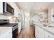 Open-concept kitchen featuring stainless steel appliances, granite countertops, and a view of the dining area and stairs at 451 Interlocken Blvd # 101, Broomfield, CO 80021